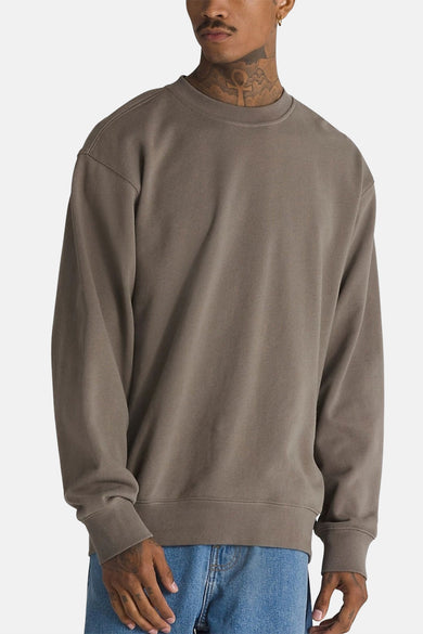 Pull marron à col rond VANS "OFF THE WALL", coupe décontractée, porté avec un jean bleu.