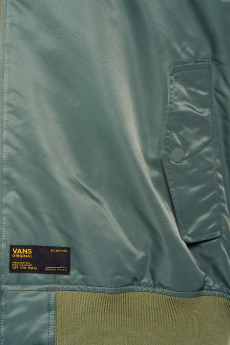 Veste courte verte VANS "OFF THE WALL" avec tissu brillant, étiquette de marque et ourlet côtelé.