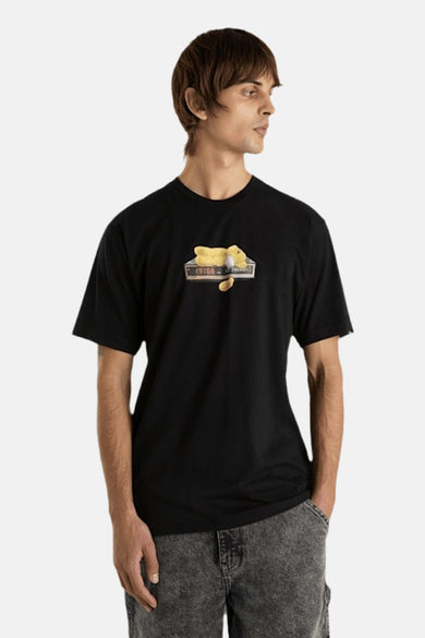 T-shirt noir à manches courtes de VANS "OFF THE WALL" avec une impression de dessin animé sur la poitrine, porté avec des jeans gris.
