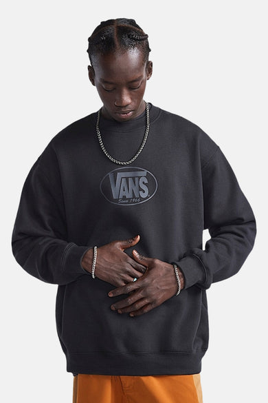 Pull-over noir de VANS avec logo sur la poitrine et chaîne et bracelets en argent.
