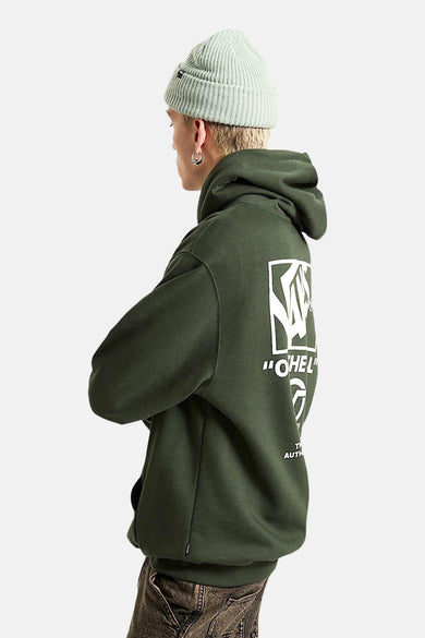 Sweater vert avec capuche VANS "OFF THE WALL", avec une impression blanche sur le dos, porté avec un chapeau vert.