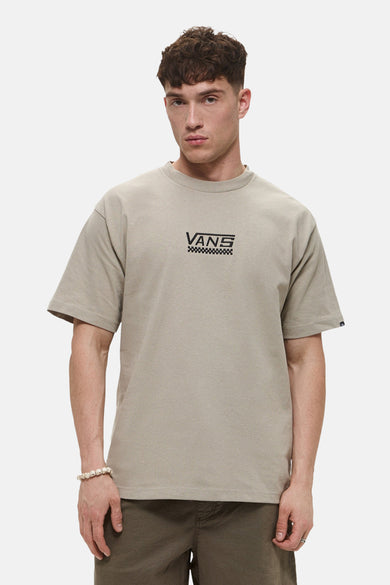 T-shirt beige à manches courtes de Vans, avec logo sur la poitrine et porté avec un bracelet en perles.
