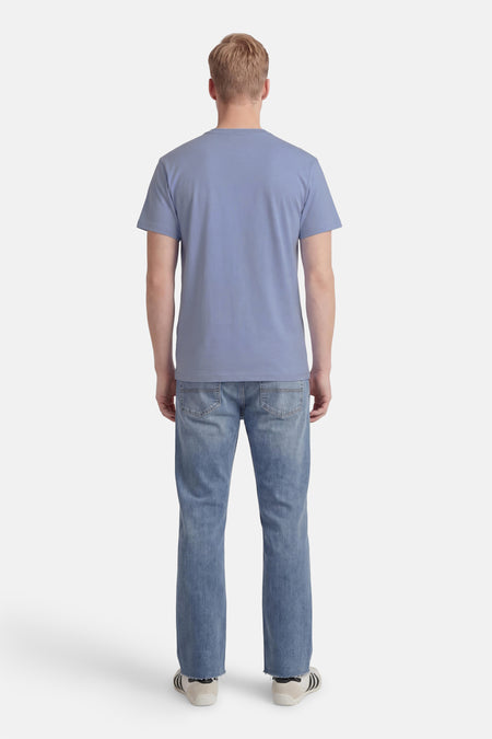 T-shirt bleu à manches courtes VANS "OFF THE WALL", vu de dos avec jean et baskets.