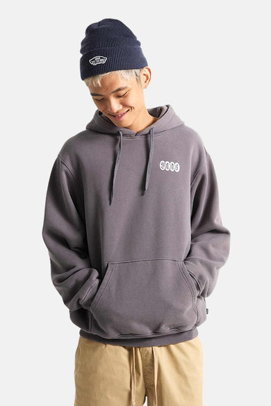 Pull gris à capuche Vans, porté avec un bonnet bleu marine et un pantalon beige.