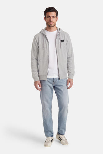 Sweat-shirt gris à fermeture éclair VANS "OFF THE WALL", avec capuche, porté sur un T-shirt blanc et associé à un jean et des baskets.