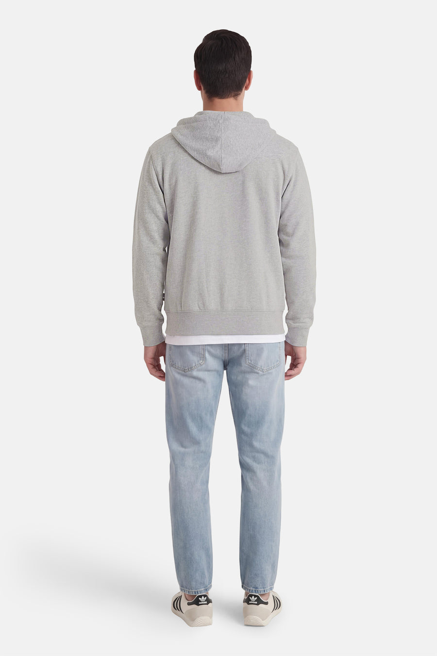 Gilet pull gris de VANS "OFF THE WALL", avec capuche, porté avec un t-shirt blanc et un jean bleu clair.