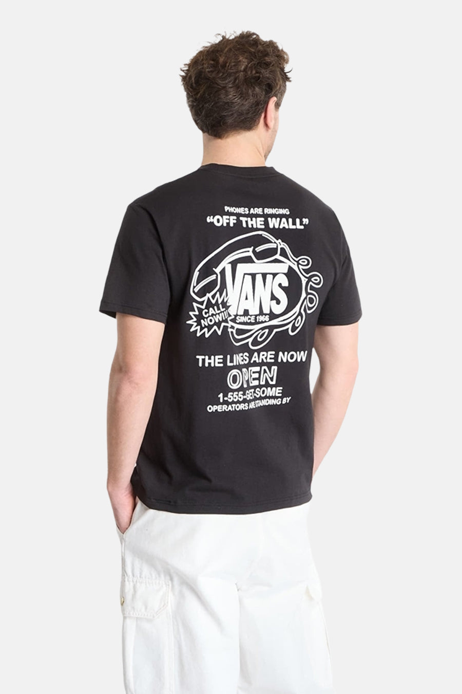 T-shirt noir VANS "OFF THE WALL" avec un imprimé de téléphone rétro blanc et divers textes au dos, vue arrière.