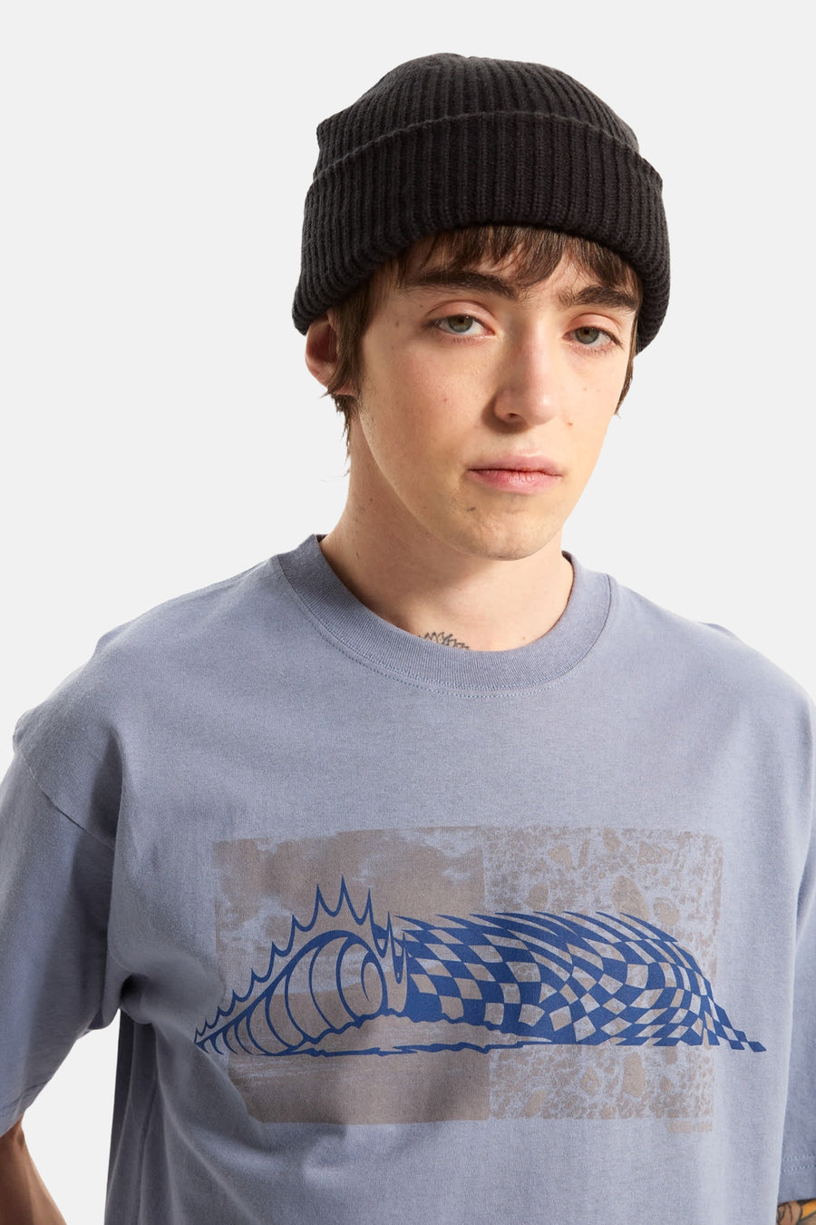 T-shirt bleu VANS "OFF THE WALL", avec un motif graphique de vagues et un bonnet tricoté noir.