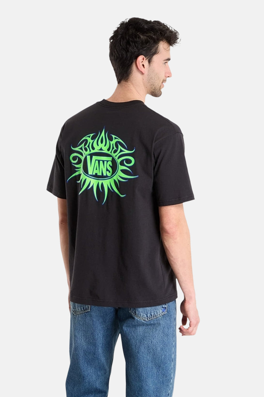 Zwart T-shirt van VANS “OFF THE WALL” met een groene print op de rug, gecombineerd met een blauwe jeans.
