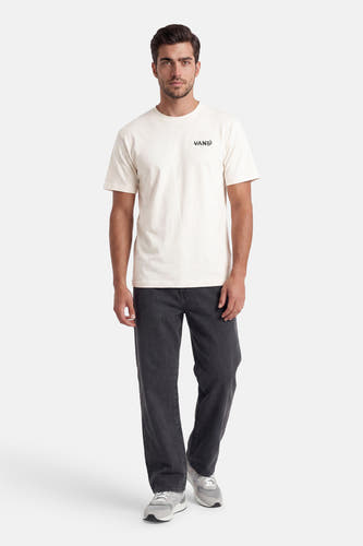T-shirt écru à manches courtes VANS "OFF THE WALL" avec logo noir sur la poitrine, porté avec un pantalon côtelé gris foncé et des baskets grises.