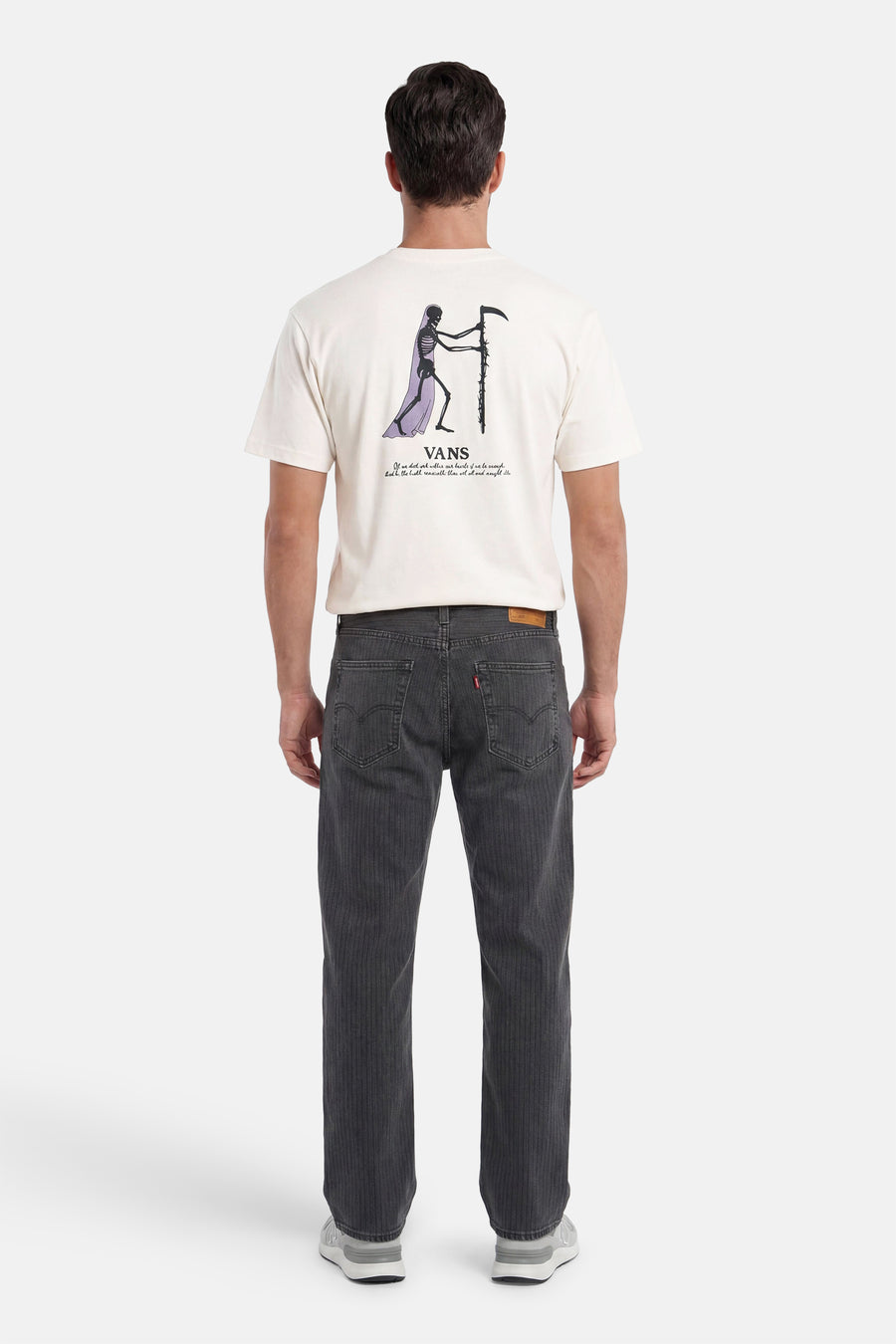 T-shirt écru VANS "OFF THE WALL" avec imprimé squelette et texte dans le dos, porté par un homme en jean côtelé et baskets.