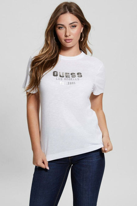 T-shirt blanc à manches courtes Guess, légèrement transparent avec texture slub, porté par un mannequin en jean foncé.