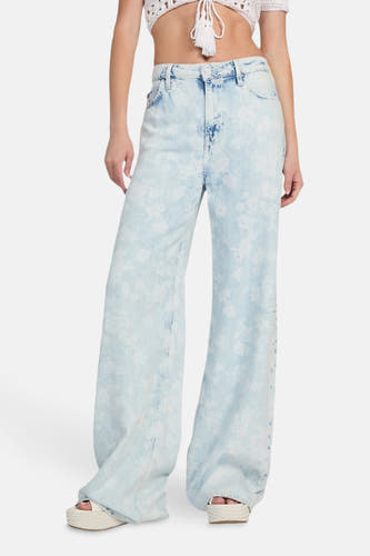 Jean décontracté de denim bleu clair de Guess, avec un imprimé fleuri all-over et des jambes larges.