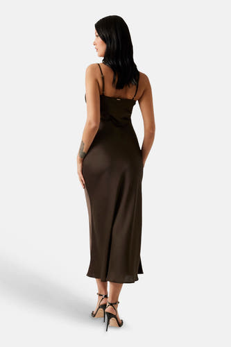Robe nuisette en satin marron de Guess, avec fines bretelles, vue de dos, portée avec des talons noirs.