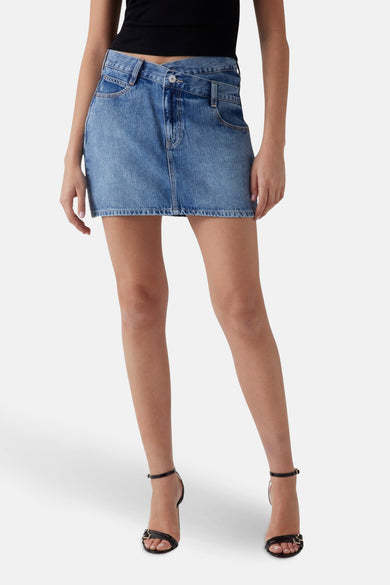 Short blue denim skirt from Guess, seen from the back, with black heels.