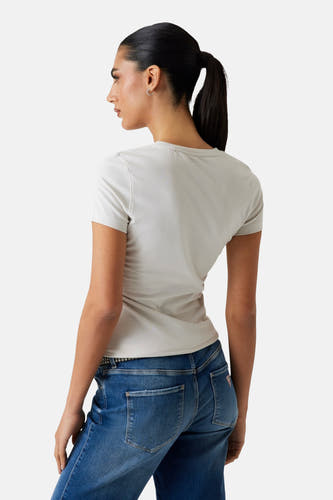 T-shirt blanc à manches courtes de Guess, porté avec un jean et une ceinture, vue arrière.