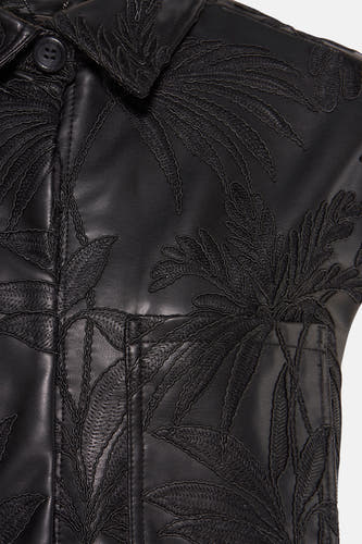 Gilet bodywarmer noir de Guess® avec un motif de feuille de palmier tropical et une poche de poitrine visible.