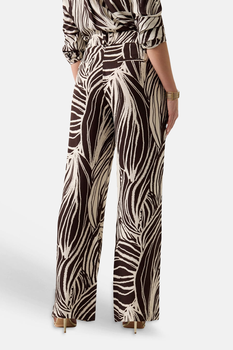 Pantalon multicolore Guess® à motif abstrait de feuilles marron-beige, jambes larges, porté par un mannequin avec un haut assorti, vue de dos.