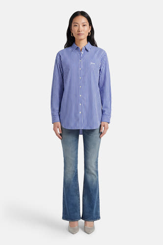 Chemise bleue rayée à manches longues de Guess, portée avec un jean et des chaussures argentées.