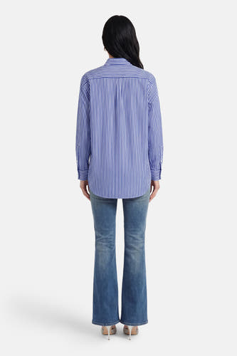 Chemise bleue à rayures à manches longues de Guess, avec une coupe droite et portée avec un jean.