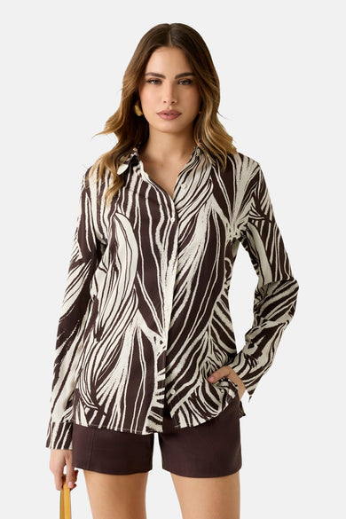 Chemise multicolore à manches longues Guess®, avec un motif zèbre abstrait, portée avec un short marron.