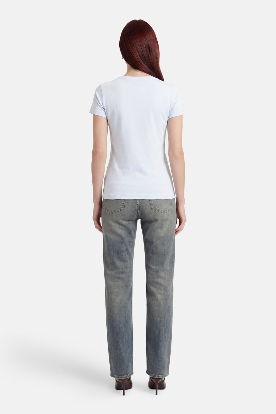 Lichtblauw T-shirt met korte mouwen van Guess, van achteren gezien met een aansluitende pasvorm, gedragen met jeans en hakken.