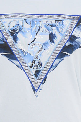 T-shirt bleu Guess® avec un logo triangulaire brillant formé de strass et un motif floral bleu.