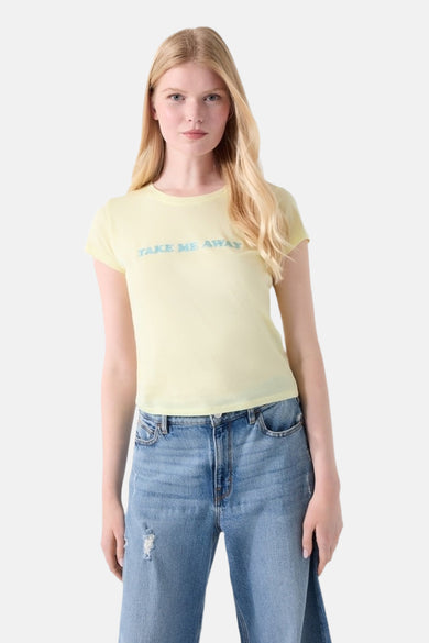 T-shirt jaune Guess à manches courtes, imprimé 'TAKE ME AWAY', porté avec un jean large délavé.