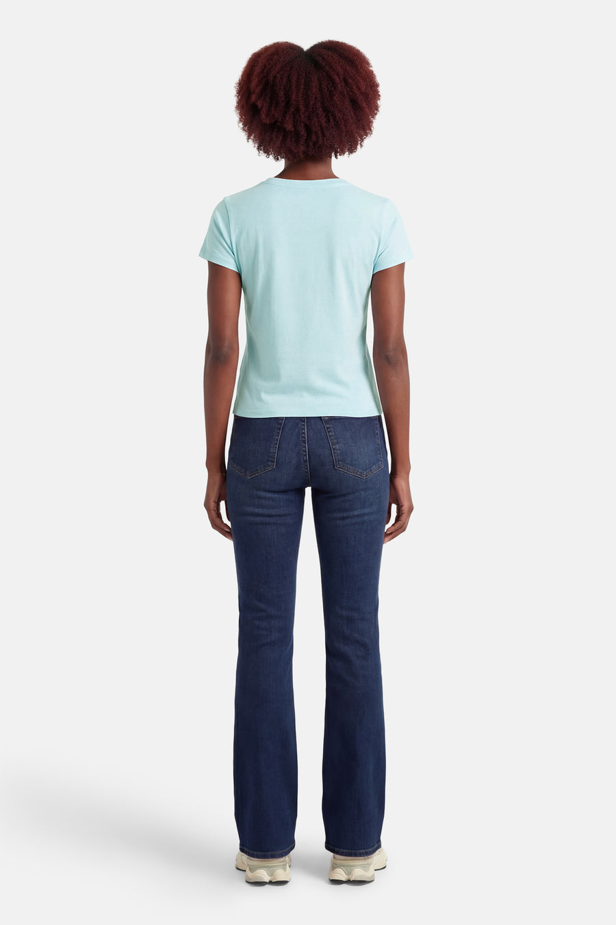 T-shirt bleu à manches courtes de Guess®, vu de dos, associé à un jean bleu foncé et des baskets blanches.
