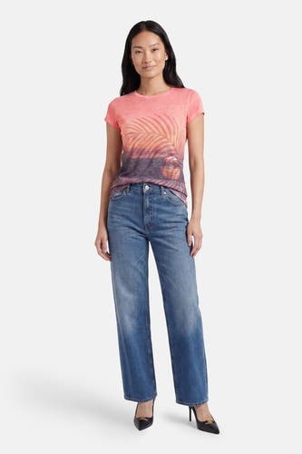 T-shirt multicolore à manches courtes Guess® avec imprimé coucher de soleil, porté avec un jean bleu et des talons noirs.