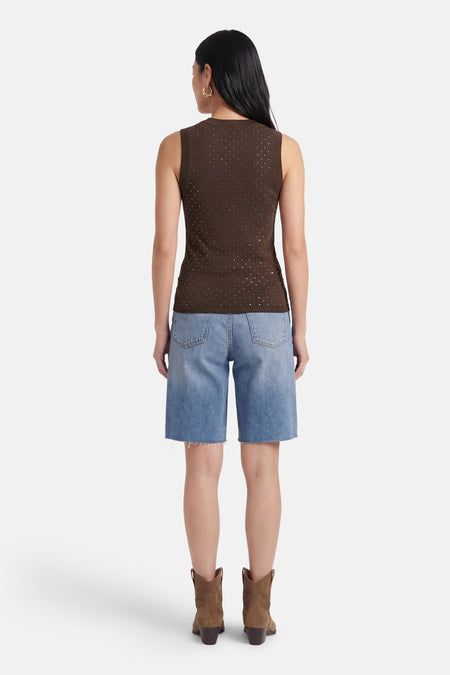 Haut sans manches marron Guess à pois argentés, vu de dos sur mannequin avec short en jean et bottes.