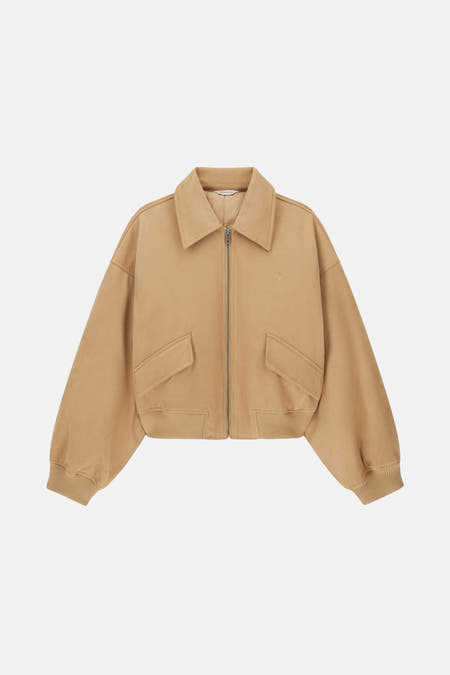 Manteau court brun de Guess, avec fermeture éclair et poches à l'avant.