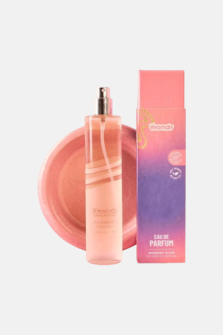 Flacon de parfum rose et boîte assortie de WONDR CARE, avec des lignes blanches sur un fond rose.