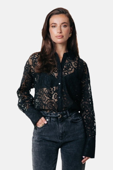 Chemise noire à longues manches de COLOURFUL REBEL, avec un motif brodé et portée avec une chemise noire et des jeans gris.