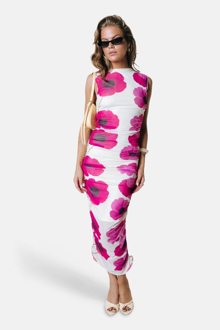 Robe sans manches multicolore de COLOURFUL REBEL avec imprimé pavot rose et plis en soie, porté de profil avec un bracelet blanc.