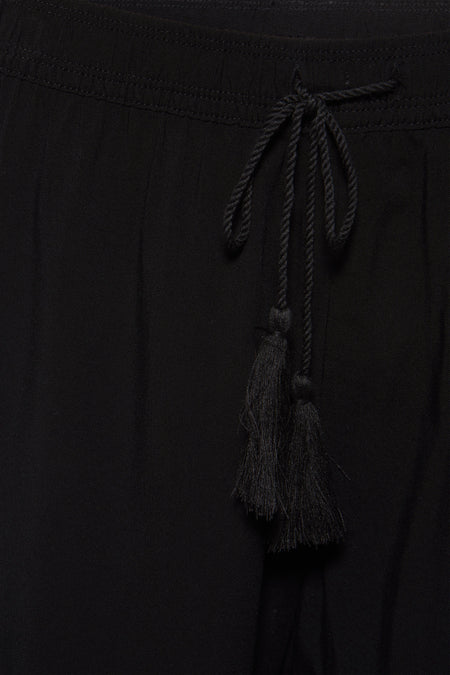 Short noir de HAILYS, avec une ceinture et des décoratifs en forme de glands à la taille.