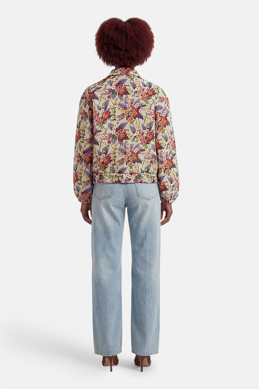 Veste courte multicolore de COLOURFUL REBEL avec imprimé floral, portée avec un jean bleu clair et des talons marron.