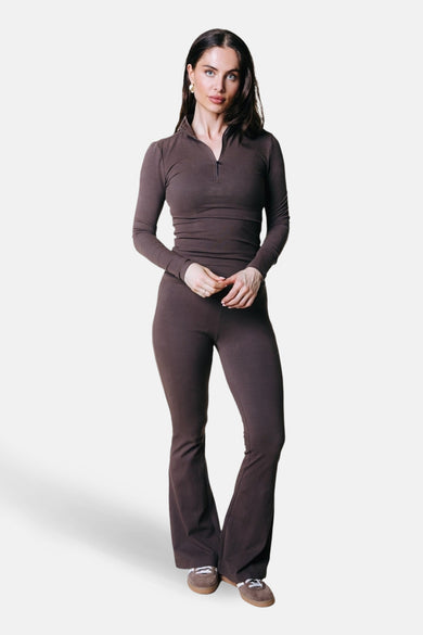 Bruine joggingbroek van COLOURFUL REBEL, gecombineerd met een bijpassende top met lange mouwen en ritssluiting en bruine sneakers.