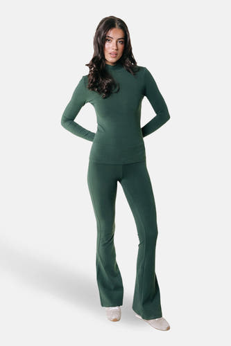 Groene joggingbroek van COLOURFUL REBEL, gecombineerd met een bijpassende groene top en witte sneakers.