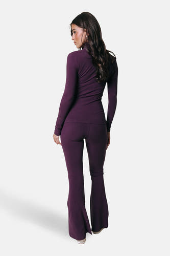 Pantalon de jogging violet de COLOURFUL REBEL, modèle évasé, vu de dos avec un haut assorti et de longs cheveux foncés.