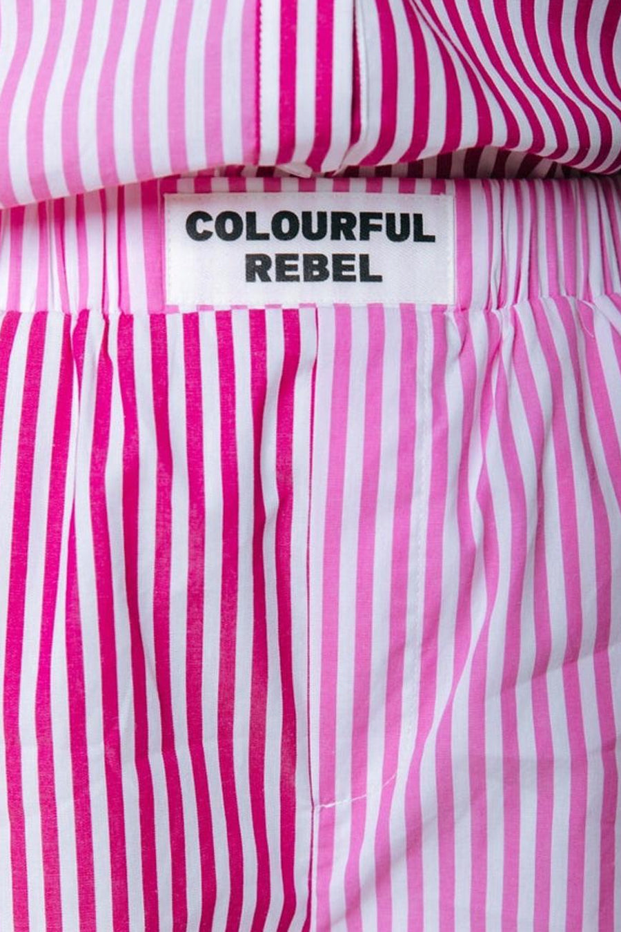 Short rayé rose de COLOURFUL REBEL avec des rayures blanches et une taille élastique.