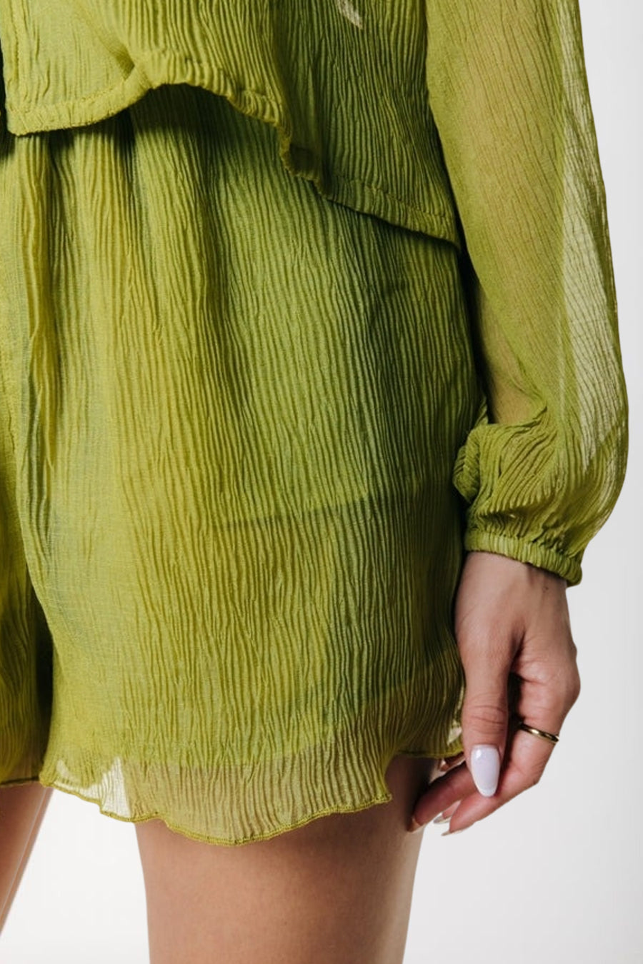 Groene korte broek van COLOURFUL REBEL, met gerimpelde textuur en waaierzoom, zijwaarts close-up.