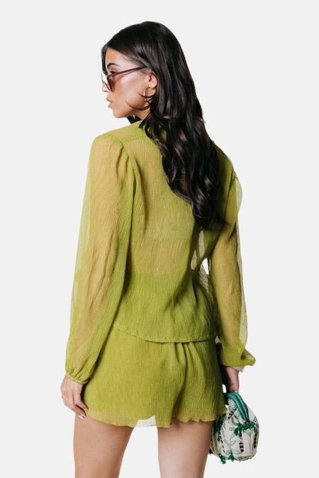 Groene korte broek van COLOURFUL REBEL, zijaanzicht, met gerimpelde textuur, bijpassend groen overhemd, model draagt kleine tas met plantenprint