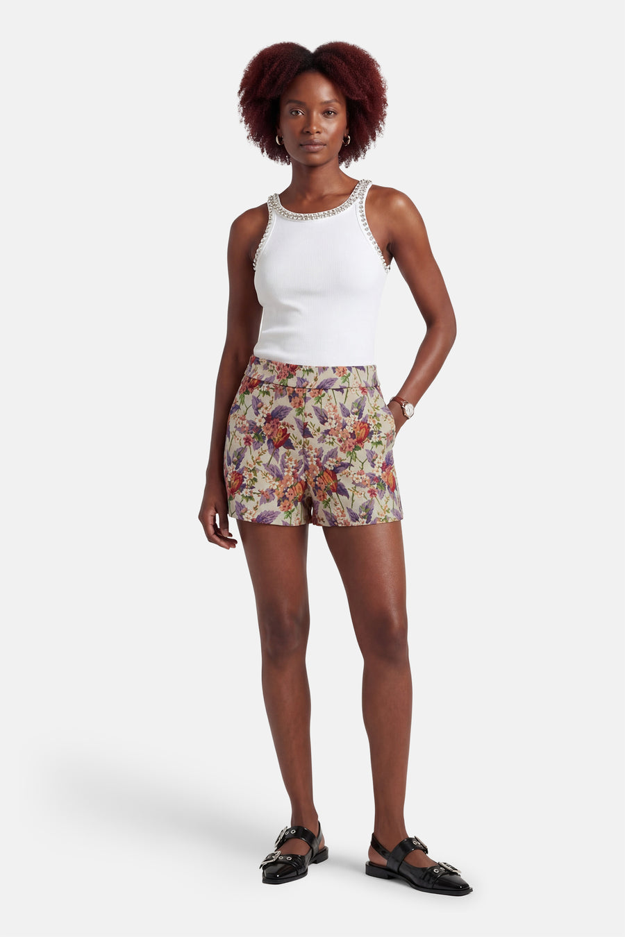 Multikleurige short van COLOURFUL REBEL, met bloemenpatroon en gedragen met een witte top met strass en zwarte sandaaltjes.
