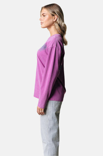 T-shirt rose à manches longues de COLOURFUL REBEL, avec un aspect vintage lavé, porté avec un pantalon rayé.