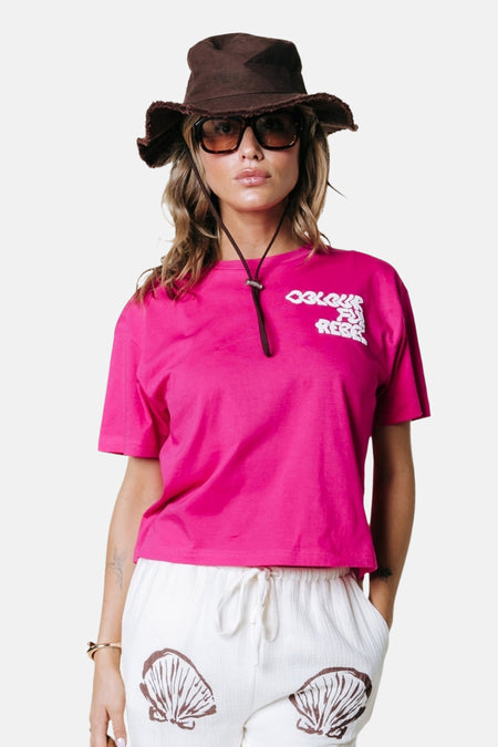 T-shirt rose de COLOURFUL REBEL à manches courtes, porté par un mannequin en vue de profil/dos avec un chapeau marron.