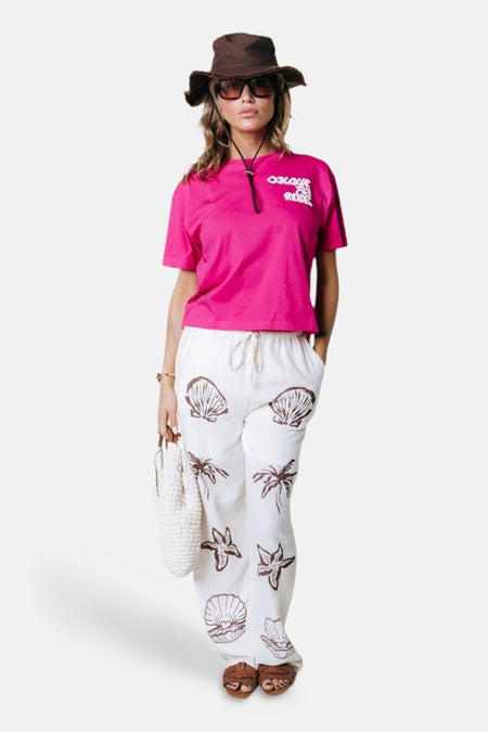 T-shirt rose de COLOURFUL REBEL avec logo blanc sur la poitrine, porté dans une tenue d'été décontractée.