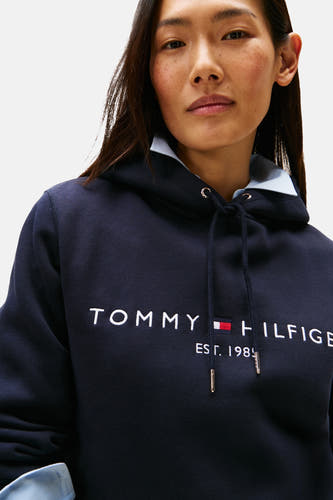 Sweat à capuche bleu Tommy Hilfiger, avec logo blanc et cordons de serrage.