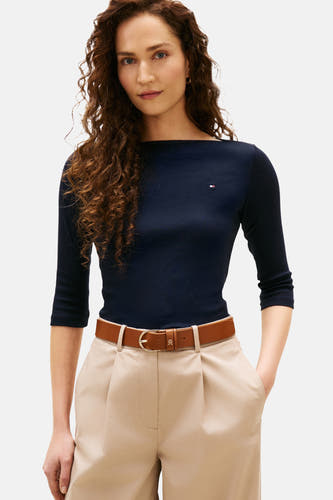 Donkerblauwe T-shirt met korte mouwen van TOMMY JEANS, met een bruine riem en beige pantalon.