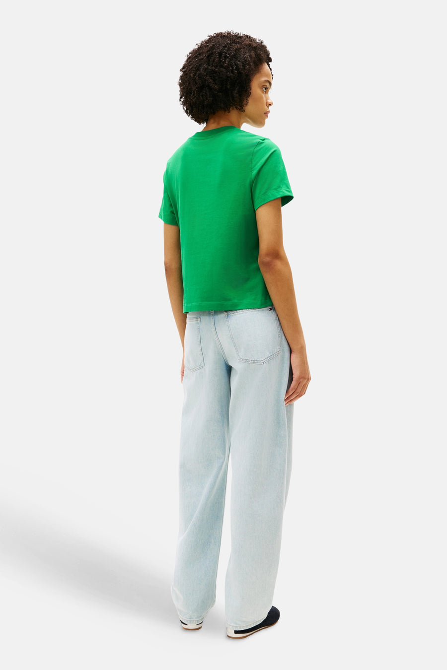 T-shirt vert de TOMMY JEANS, vu de dos, combiné avec un jean ample bleu clair.